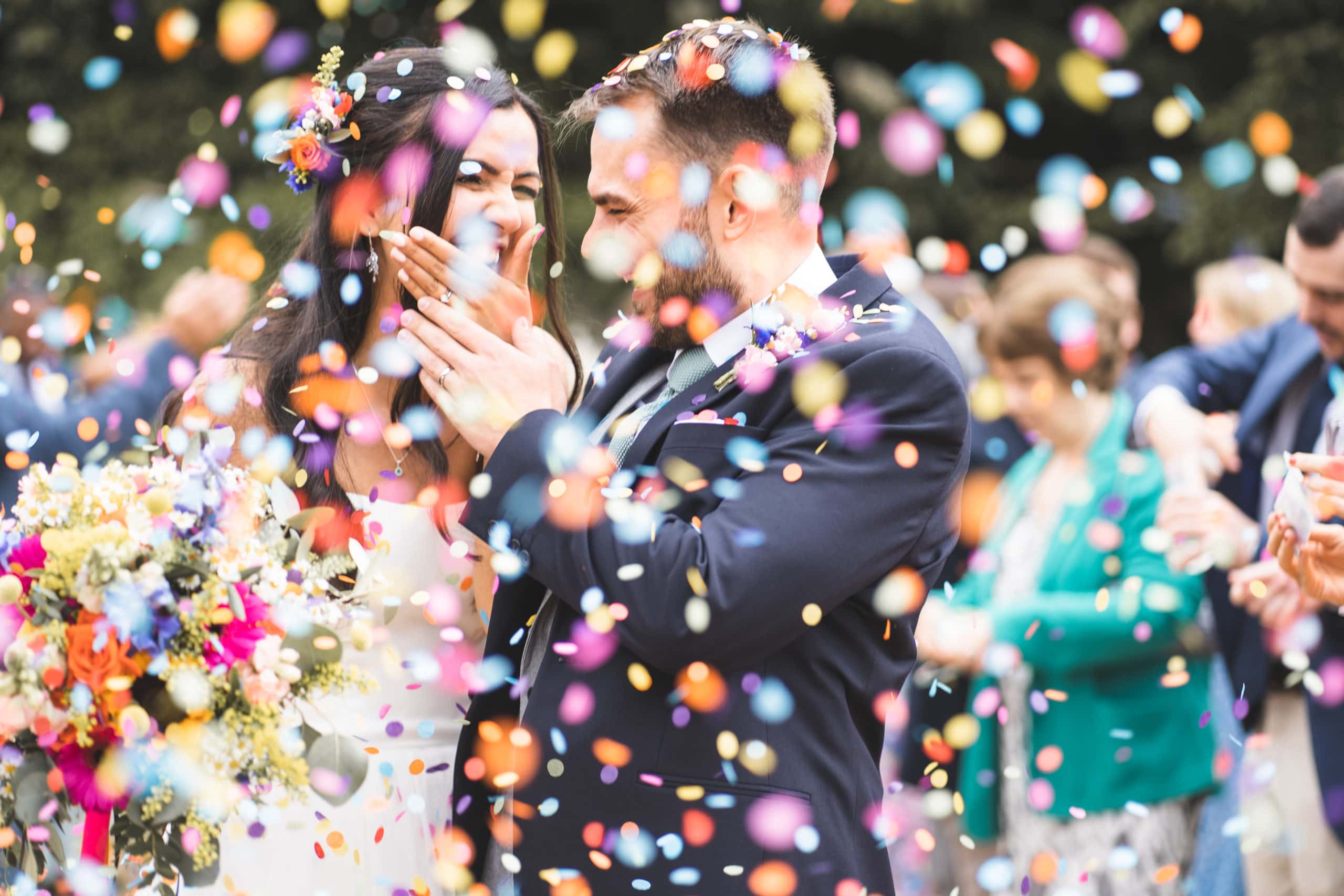 Bride and groom being showered with confetti
