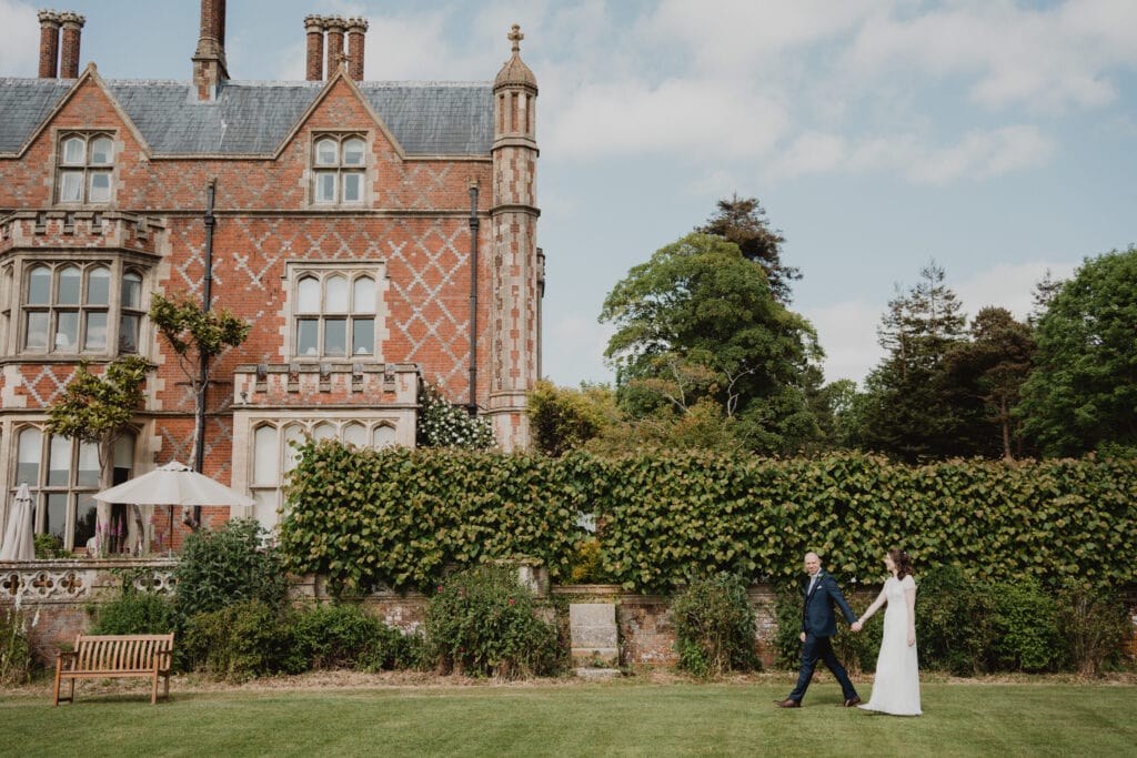 Couple walking hand in hand in the gardens at Horsted Place Hotel